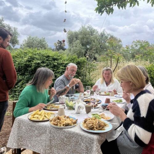 Group is sitting for Cretan Dinner Farm-To-Table-Experience Crete Farm-zu-Tisch Erlebnis mit Zutatensuche Schatzsuche Kreta